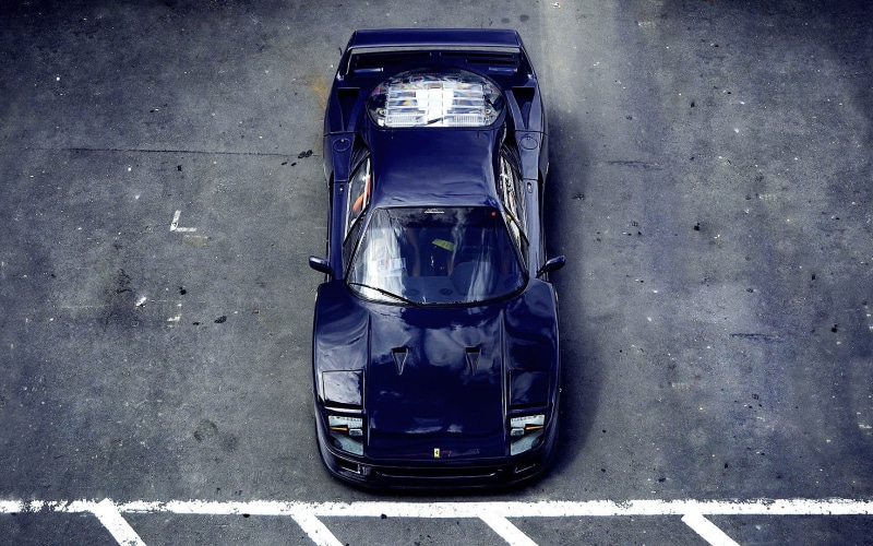 sign, symbol, 720P, top view, high angle view, sports, no people, car, Ferrari F40, outdoors, motor vehicle, city, blue, road marking, architecture, asphalt