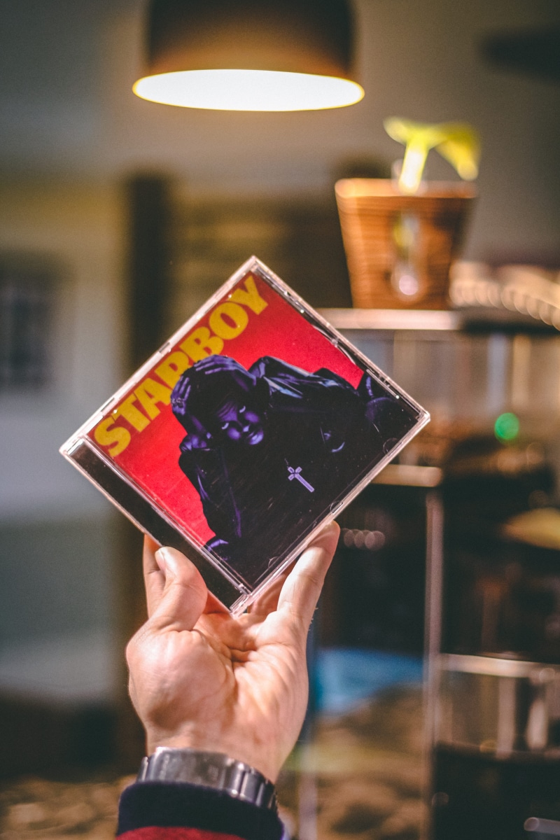 technology, the weeknd, music, flower, lighting equipment, photography themes, human hand, real people, photographing, hand, trademark, focus on foreground