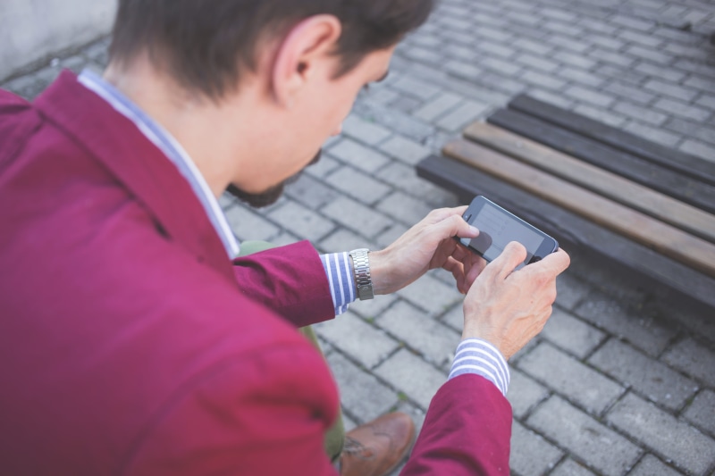 adult, casual clothing, using phone, 5K, cobblestones, communication, wireless technology, jacket, day, person, mobile phone, magenta, smart phone, young adult