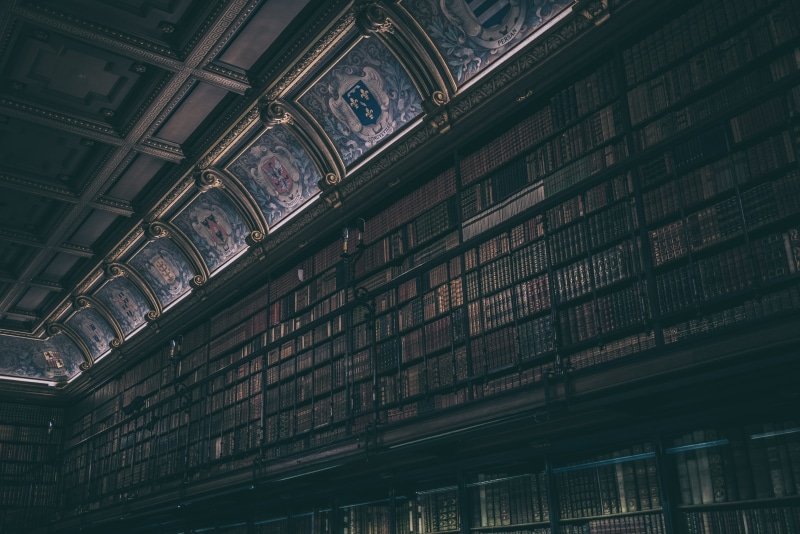 indoors, railroad station, low angle view, ornate, old, building, the past, ceiling, book, arrange, built structure, bookcase, library interior, lot, transportation