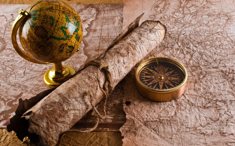 no people, healthy eating, scrolls, compass, time, animal representation, still life, indoors, antique, desk, directly above, globes, food and drink, yellow