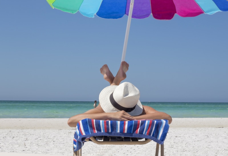 sun, destination, tanning, sun hat, shore, blue, sea, sand, travel, parasol, landscape, one person, recreation, season, resort, day, beauty in nature, ocean