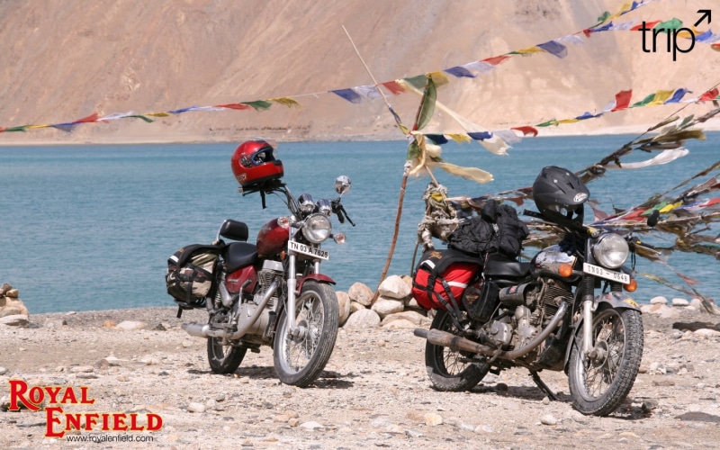 two, outdoors, mode of transportation, royal, full length, leisure activity, lifestyles, ride, crash helmet, extreme sports, motorcycle, riding, enfield