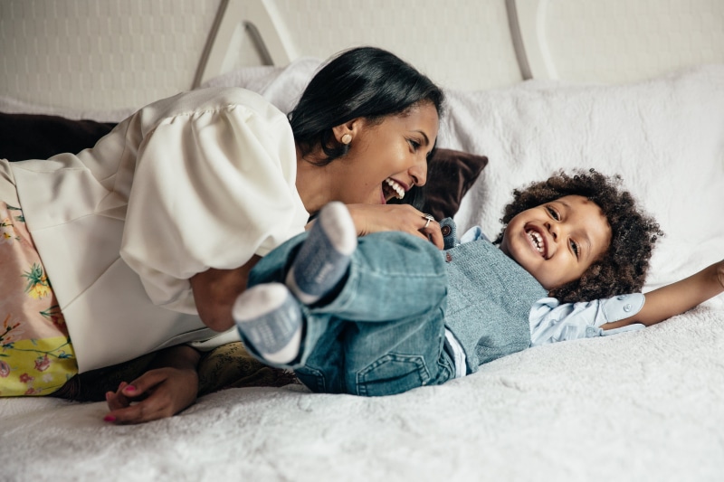 Bedroom, Family, mother, wireless technology, women, domestic life, photo, lifestyles, son, Mom, daughter, Home, lying down, Fun, indoors, tickling, parent