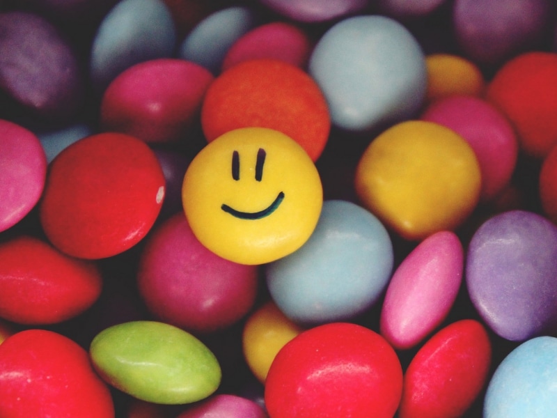 full frame, anthropomorphic face, smiling, anthropomorphic smiley face, close-up, food, large group of objects, yellow, indoors, emoji, abundance, no people