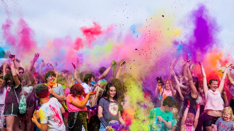 throwing, neon, people, rave, emotion, ground - culinary, dust, fun, multi colored, togetherness, festival, excitement, real people, joy, crowd, hand raised