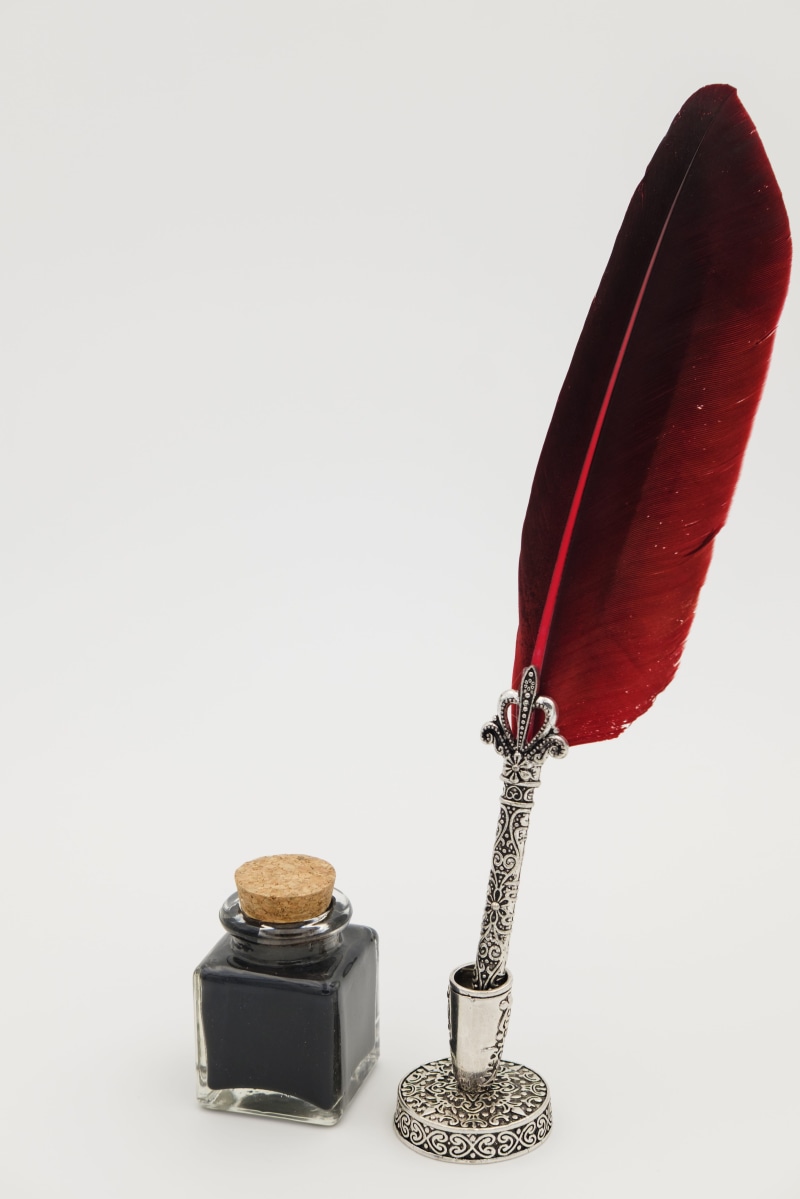 copy space, black color, beside, communication, pen, feather, writing instrument, man made, writing implement, wood - material, ink, red, bottle, white background