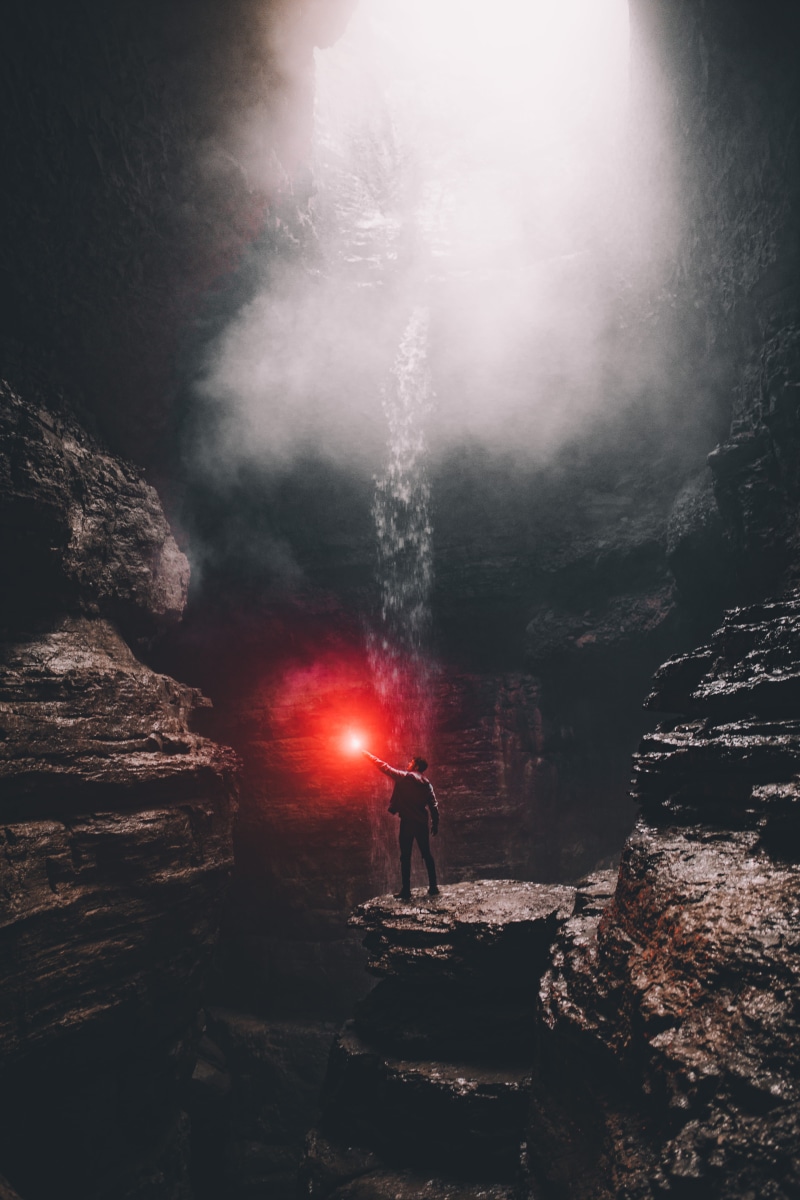 standing, glare, red, smoke - physical structure, solid, inside, nature, mist, contrast, underground, rock - object, outdoors, adventure, cave, architecture