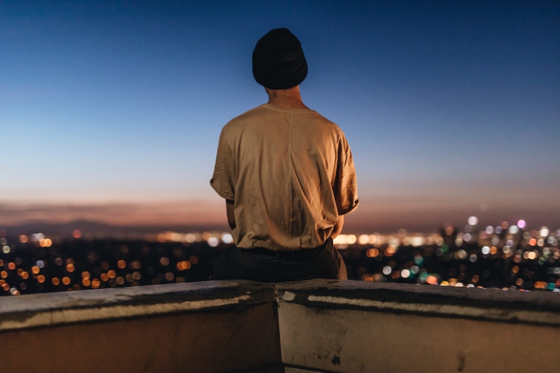 fence, looking, skyscraper, rooftop, real people, nature, city, illuminated, buildings, one person, night, ledge, focus on foreground, building exterior