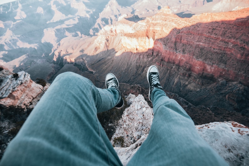 human limb, layered rock, landscape, cliff, heights, adventurer, legs, non-urban scene, outdoors, mountain, shoe, human body part, activity, top, outdoor