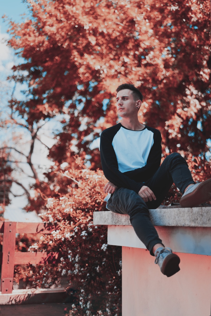 change, looking, sitting, ledge, one person, facial expression, looking away, male, real people, tree, attractive, leisure, lifestyles, pose, man, focus