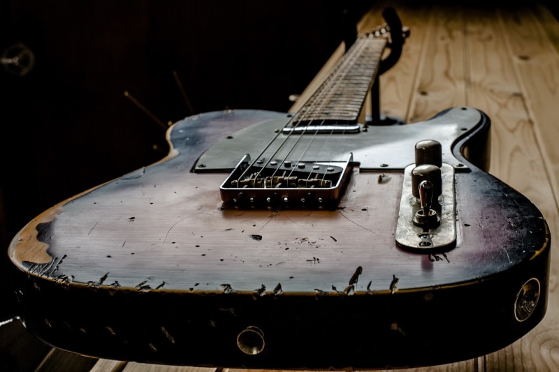 black background, indoors, focus on foreground, knob, still life, guitar, white color, musical instrument, studio shot, arts culture and entertainment