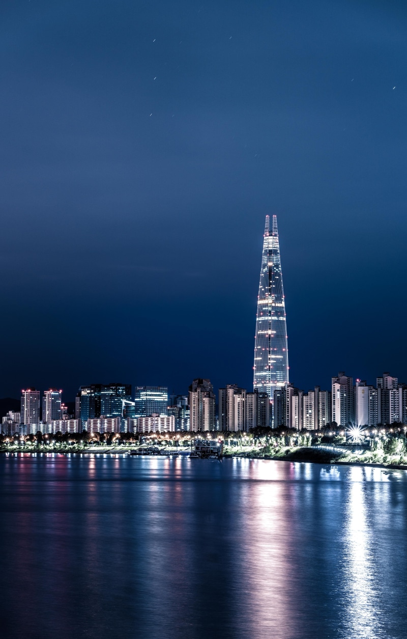 building, sky, travel destinations, reflection, night photography, waterfront, night view, sea, built structure, outdoors, a night view of seoul, financial district