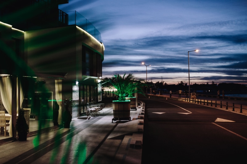 sky, sago palm, urban Scene, tropical, palm, transportation, cityscape, leaves, building Exterior, green, road, street light, twilight, sign, the way forward