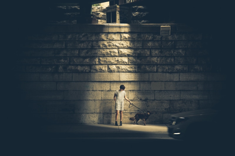 silhouette, light, lamp, holding, real people, broom, night, adult, outfit, skirt, sidewalk, girl, one person, nighttime, road, child, wall, wearing, full length