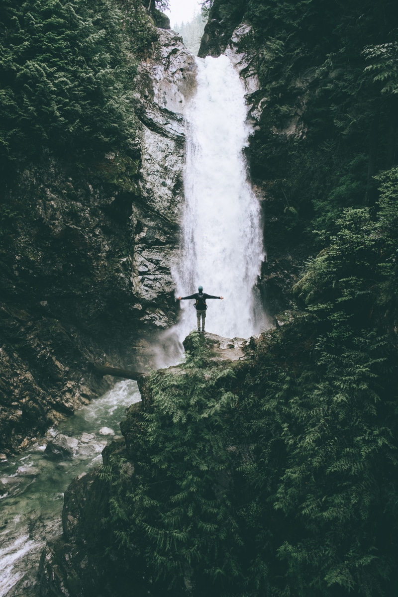 tree, sport, flowing, standing, man, travel, rock, plant, outdoors, waterfall, people, aquatic sport, sea, daytime, person, 5K, river, edge, surfing, hiking