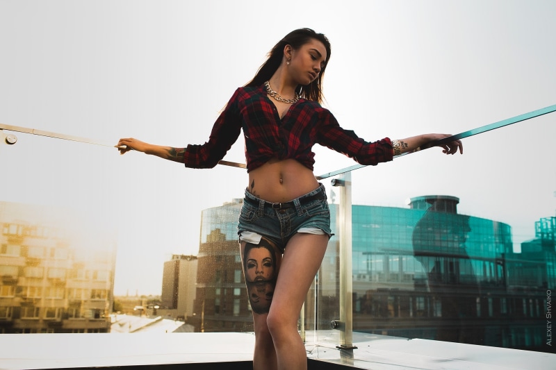 real people, fashion, limb, beautiful woman, jean shorts, built structure, building exterior, shirt, young adult, young women, tattoo, one person, outdoors
