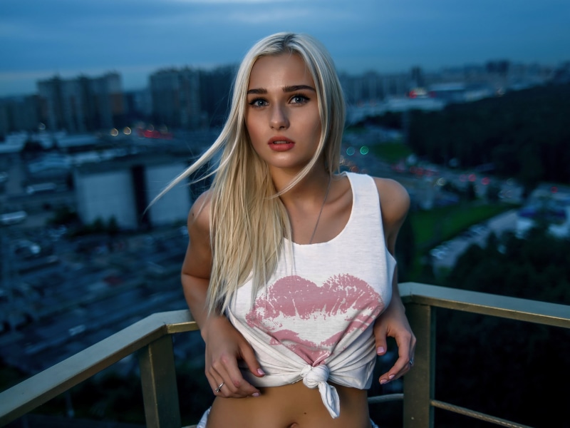 tanned, balcony, portrait, hairstyle, one person, casual clothing, long hair, depth of field, fashion, railing, blonde, looking at camera, young adult