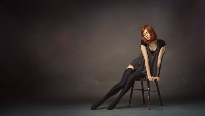one person, indoors, fashion, contemplation, beauty, sleeved, full length, dress, redhead, studio shot, seat, beautiful woman, closed eyes, short hair