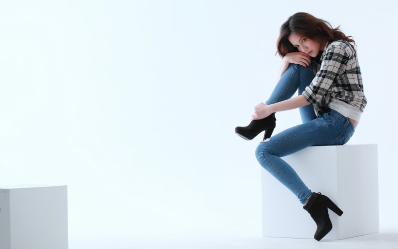 auburn hair, black, real people, side view, looking, brown eyes, blue, legs, sitting, white background, indoors, day, woman, 2K, lifestyles, contemplation
