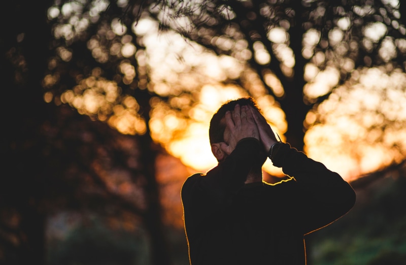 holding, headshot, outdoors, cry, relaxation, portrait, sunlight, arms raised, sky, focus on foreground, covering, young Adult, one Person, men, nature