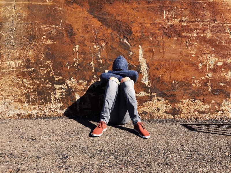 real people, full length, social issues, wall, young, depressed, outdoors, youth, sitting, clothing, alone, boy, day, lifestyles, front view, city, 2K
