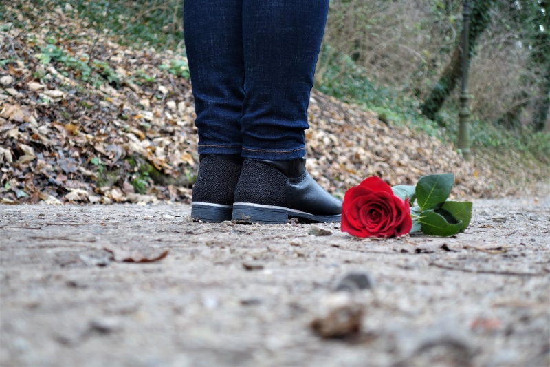 lost love, shoe, female model, standing, red rose on the floor, sorrow, casual clothing, human leg, modelling, emotional, woman, human body part, outdoors