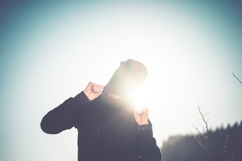 enjoyment, cloudless, sunlights, waist up, Hiding, adults only, room for text, limb, front view, copy Space, smiling, Cap, day, body part, fun, one man only