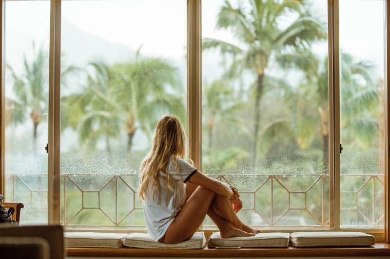 adults only, near, cushion, facing, relaxation, bench, leisure activity, females, real people, white, glass - material, tree, one Woman Only, Rainy Day