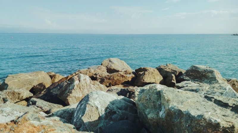 idyllic, tranquility, rock, horizon over water, rocky coastline, beauty in nature, non-urban scene, sky, beach, brown, boulder, sea, clear sky, rock - object