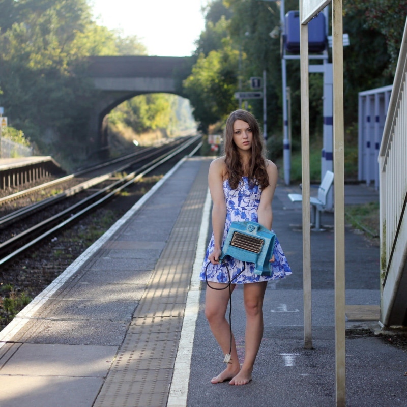 young adult, waiting, long hair, dress, bare shoulders, looking at camera, transportation, casual clothing, 720P, blue, barefoot, s, beautiful woman, hair