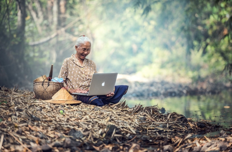 technology, computer, forest, one person, lifestyles, surfing the net, smiling, happiness, laptop, sitting, land, senior adult, communication, wireless technology