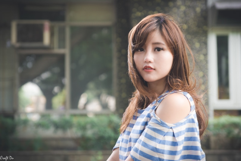long hair, childhood, long eyelashes, real people, contemplation, hair, looking at camera, women, standing, focus on foreground, headshot, outdoors, striped clothing