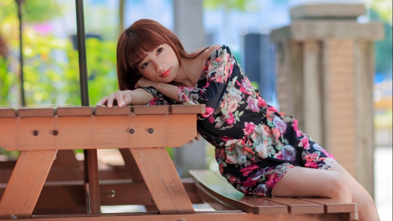 long hair, red lipstick, table, 1080P, girls, beautiful woman, wood - material, brown eyes, women outdoors, focus on foreground, wood, looking at camera