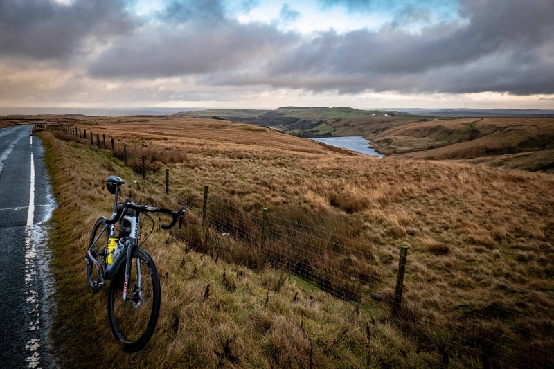 landscape, black, brown, land, mountain bike, gravel, dirt road, bicycle, near, headwear, bunker, non-urban scene, adventure, wheel, sport, sky, mountain