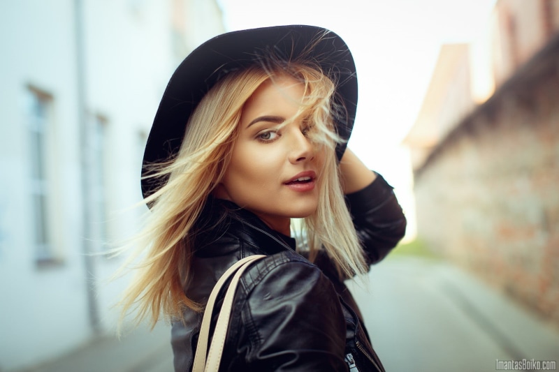 street, windy, leather jackets, buildings, blond hair, hat, beauty, concrete, young women, woman, portrait, beautiful woman, headshot, focus on foreground