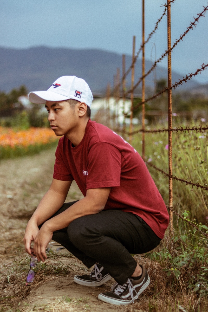 leisure activity, flower, pants, contemplation, men, land, human, plant, baseball cap, grass, nature, lifestyles, garden, tire, young adult, young men