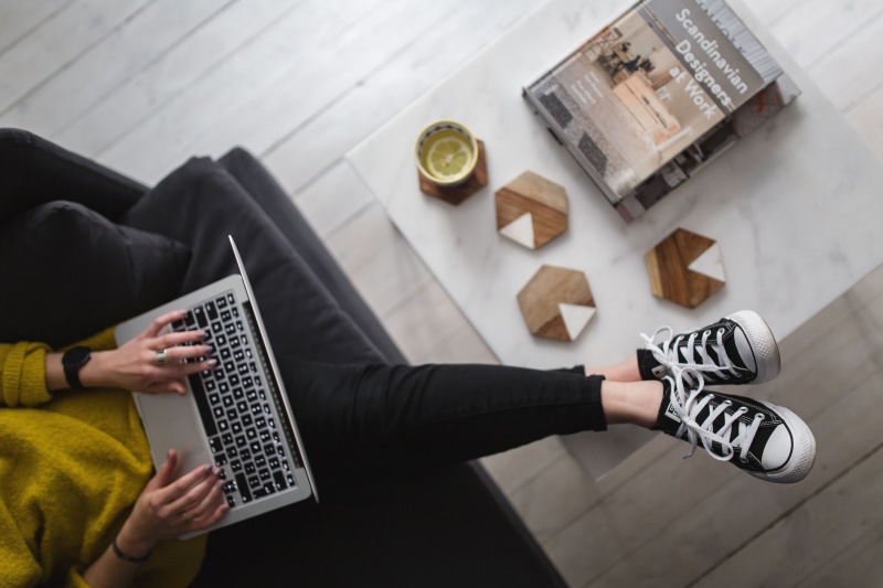 leisure activity, white floor, coffee table, adults only, young, blonde, caucasian Ethnicity, computer, minimal, sitting, adult, mid adult, person, apple macbook
