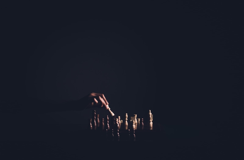 person, board, architecture, body part, chess, chess pieces, leisure activity, human limb, pawn, battle, metal, light, chess game, finger, copy space, lifestyles