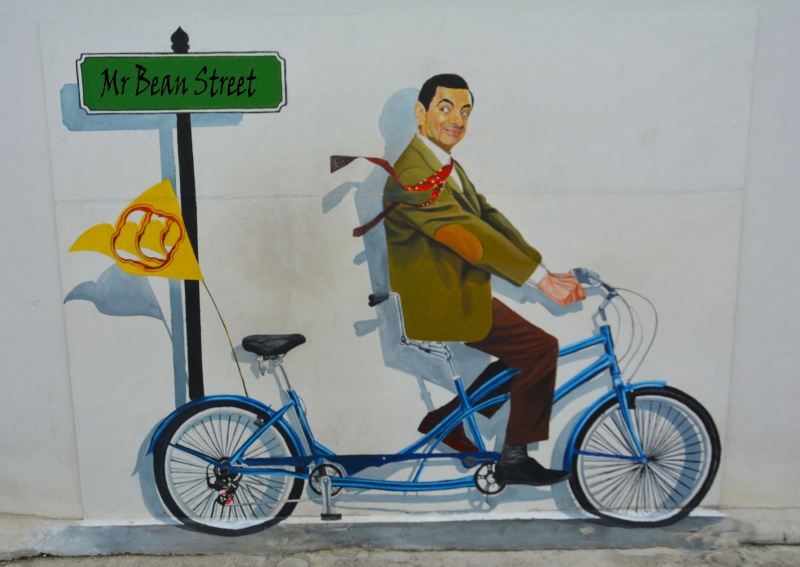 draw, day, lifestyles, looking at camera, mural, urban, outdoors, standee, mode of transportation, portrait, colorful, blue, smiling, cycling, guidance