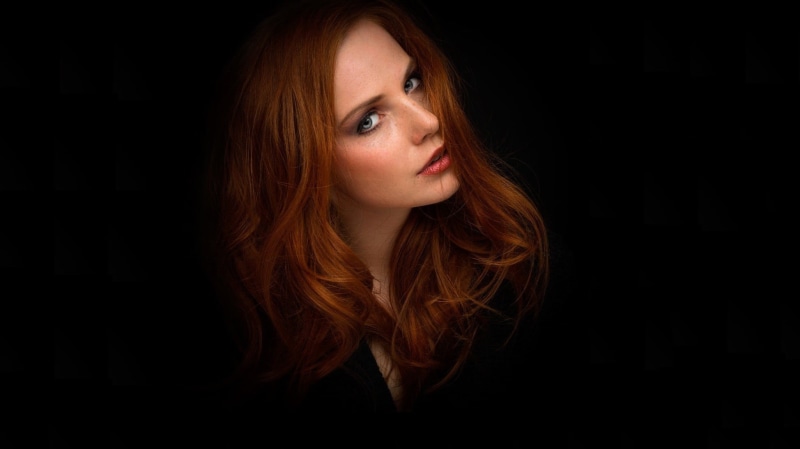 fashion, one person, copy space, hairstyle, portrait, looking at camera, hair, headshot, dyed red hair, human hair, beauty, long hair, black background
