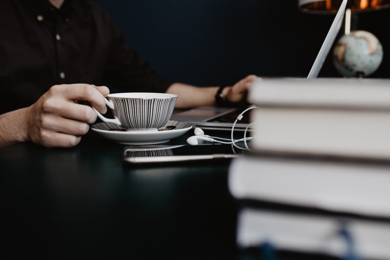 crockery, indoors, laptop, working, cappucino, communication, workspace, desk, hand, food and drink, coffee - drink, adult, male, technology, drink, busy