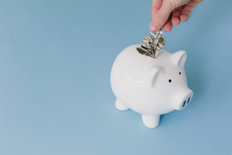 saving, inserting, Piggy bank, one person, blue, currency, hand, studio shot, copy space, blue background, finger, savings, wealth, silver colored, coin