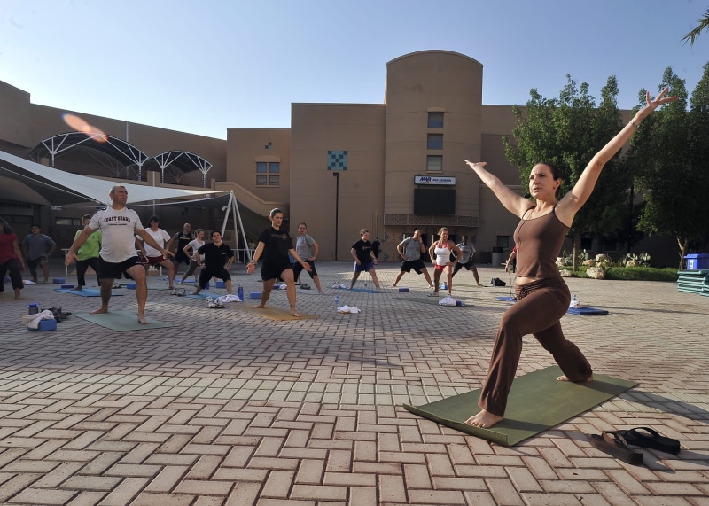 practicing yoga, wellness, motion, stretching, group of people, human limb, relaxation, asana, group, posture, city, large group of people, building exterior