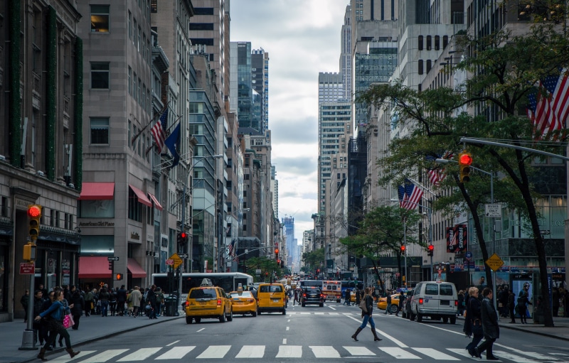 big apple, cars, city street, taxi, NY, flags, traffic light, vehicles, land vehicle, traffic, bus, outdoors, modern, built structure, flag, sign, america