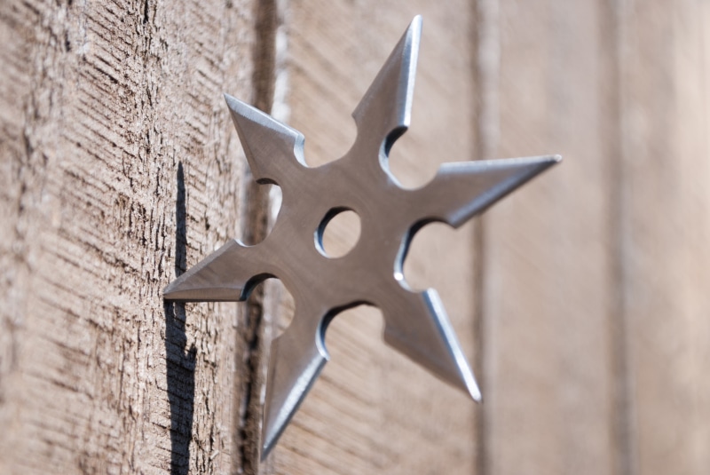 selective focus, macro, Shinobu, ninjutsu, hole, nature, blur, wooden surface, brick, focus on foreground, shuriken, blade, shape, brown, metal, center target goal
