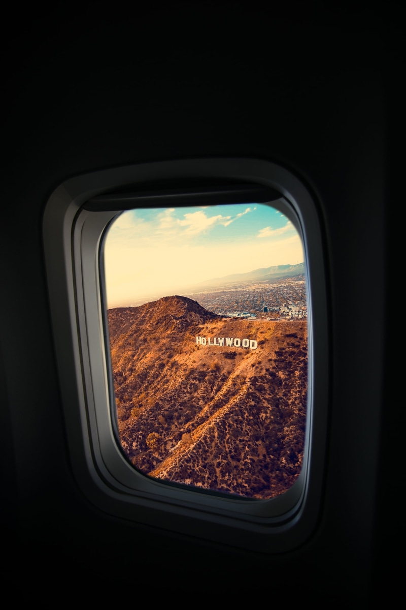 flying, vehicle interior, person, inside, airplane, cityscape, indoors, mode of transportation, sign, landscape, la, hollywood, travel, los angeles, hill