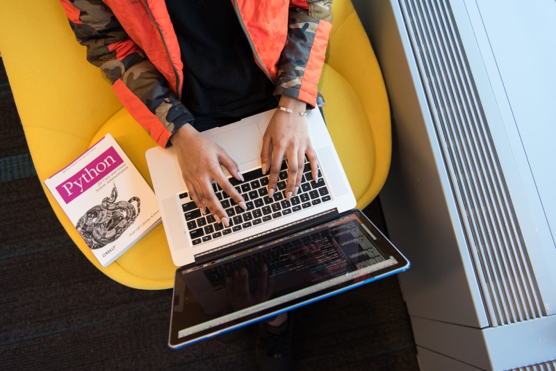 using laptop, one person, computer, book, young adult, close-up, python, internet, high angle view, macbook, equipment, midsection, coding, technology