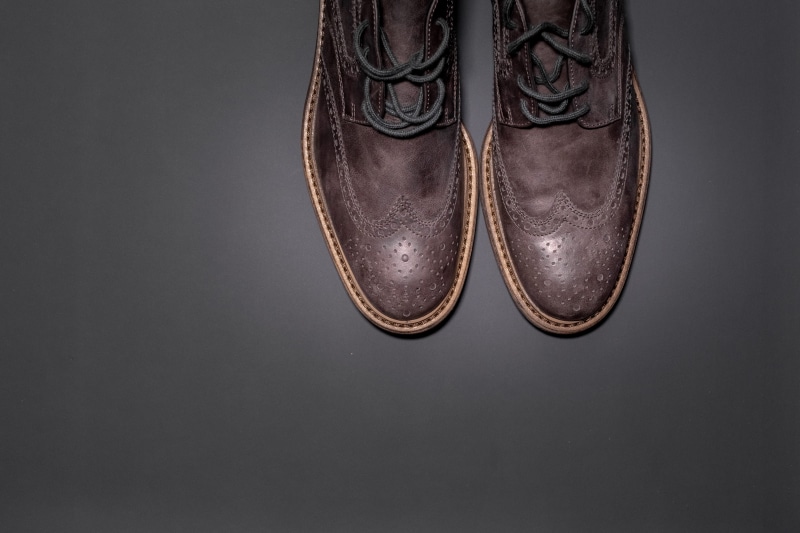 human foot, flooring, rope bridge, leather, footwear, suede, cowboy boot, gray, body part, pair, adult, menswear, close-up, style, apparel, formal, dress