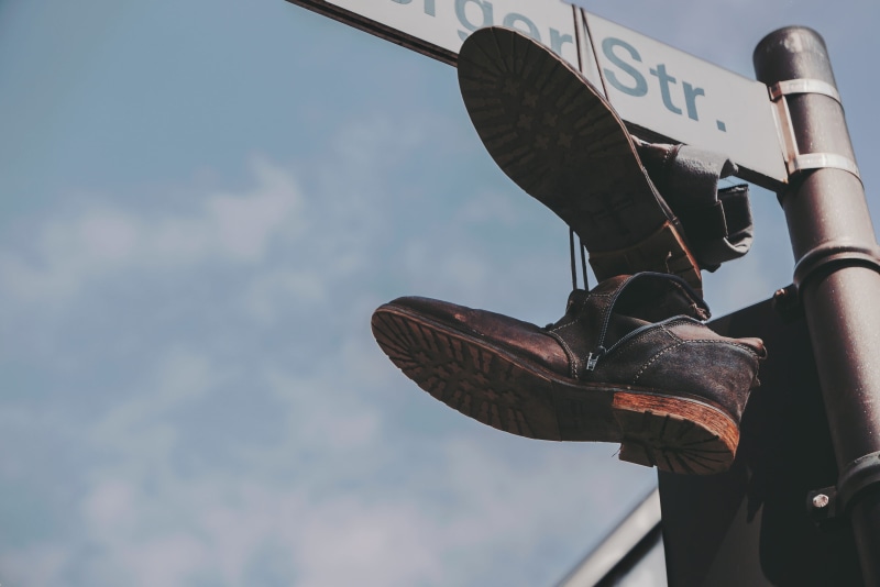 focus on foreground, sign, signage, outdoors, protection, nature, shoes, dangling, boots, mode of transportation, travel, hanging, boot, communication